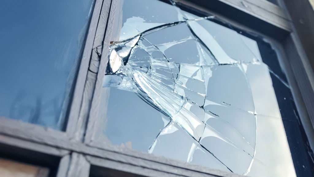broken glass window reflecting blue sky