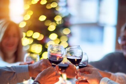 woman in white long sleeve shirt holding wine glass