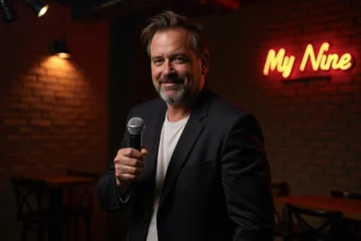 Humoriste masculin sur scène de club de stand-up pratiquant l'humour noir avec un sourire sardonique et un micro à la main