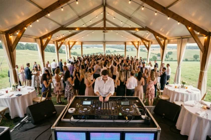 DJ professionnel en performance lors d'un événement festif en plein air dans l'Oise, avec foule dansante et décor champêtre
